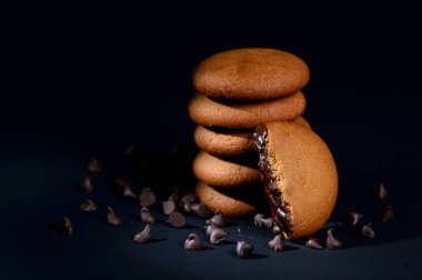 Bisküviler - Siyah arka planda çikolata kremalı leziz kremalı bisküviler