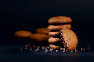 Bisküviler - Siyah arka planda çikolata kremalı leziz kremalı bisküviler