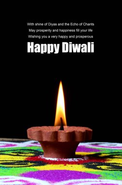 Arka planda Rangoli, Diwali kutlaması sırasında Clay diya lambaları yanıyor.