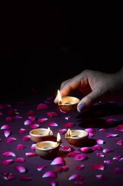 Diwali Işık Festivali sırasında el ele tutuşup fener düzenleme (Diya)