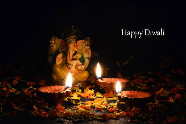 在排灯节庆祝期间, 粘土 diya 灯与主甘妮莎点燃。贺卡设计印度印度教光节叫排灯节 — 图库照片