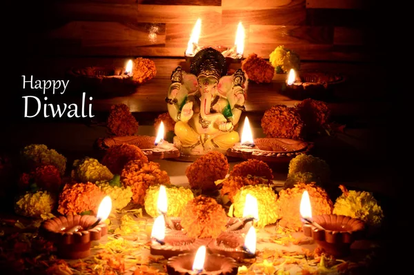 在排灯节庆祝期间, 粘土 diya 灯与主甘妮莎点燃。贺卡设计印度印度教光节叫排灯节 — 图库照片