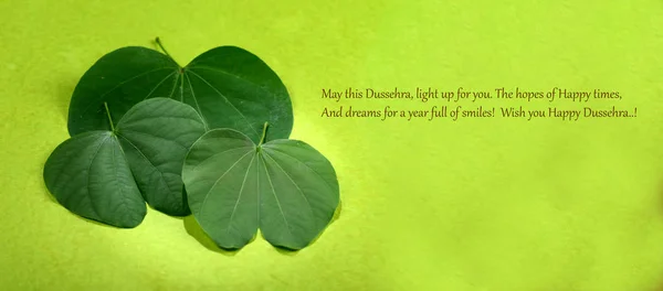 Indian Festival Dussehra, showing golden leaf and flowers on green background. Greeting card. — Stock Photo, Image