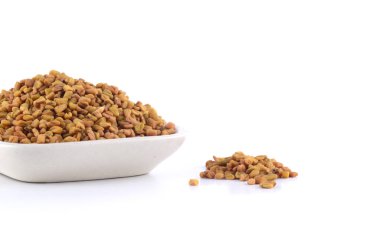 Beyaz arkaplanda izole edilmiş beyaz tabakta çemen ağacı tohumları