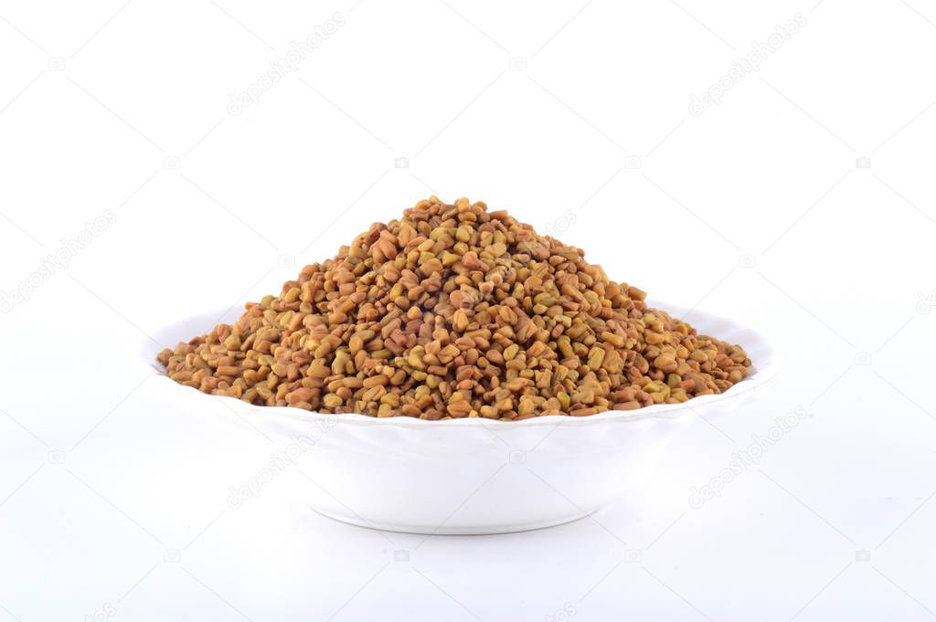 Fenugreek seeds in white plate isolated on white background