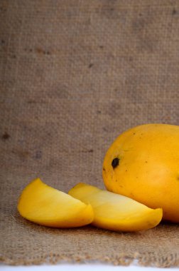 Kumaş arka planda dilimlenmiş mango meyvesi