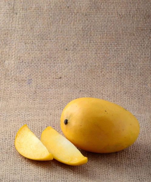 袋布の背景にスライスとマンゴーの果物 — ストック写真