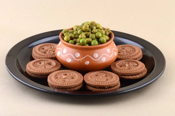 Indian snack: Cream Biscuit and Spiced fried green peas (chatpata matar) in plate. — Stockfoto