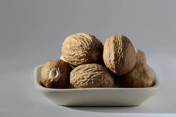 Close up of Nutmeg in a white plate — Stock Photo, Image