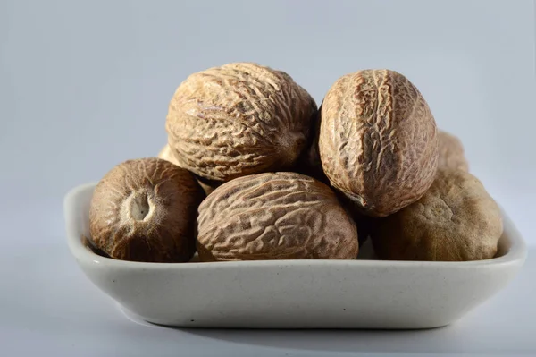 Close up of Nutmeg in a white plate — Stock Photo, Image