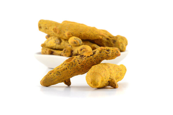 Dry Turmeric roots or barks in white plate isolated on white background