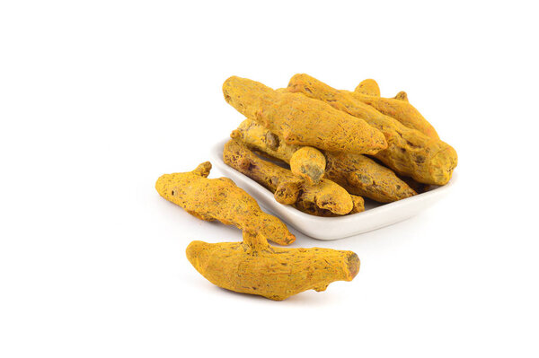 Dry Turmeric roots or barks in white plate isolated on white background