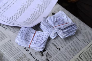 Nagpur, Hindistan - 15 Ekim 2014: Kimliği belirsiz kişiler ve anket memurları listede bir seçmen adı arıyorlar ve seçim sırasında oy kullanma sürecini hızlandırıyorlar