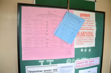 Nagpur, Hindistan - 15 Ekim 2014: Kimliği belirsiz kişiler ve anket memurları listede bir seçmen adı arıyorlar ve seçim sırasında oy kullanma sürecini hızlandırıyorlar