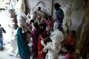 Mumbai, Maharashtra - 24 Ağustos 2014: Sanatçı Hindu tanrısı Ganesha 'nın bir putuna son rötuşları yapıyor. Ganesha festivali için bir atölye çalışması, 24 Ağustos 2014, Maharashtra, Hindistan.
