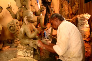 Nagpur, Maharashtra - 3 Ağustos 2014: Sanatçı 3 Ağustos 2014 'te Hindistan' ın Maharashtra kentinde Ganesha-Festivali için bir sanatçı atölyesinde Hindu tanrısı Lord Ganesha 'nın bir putuna son rötuşlarını yaptı..