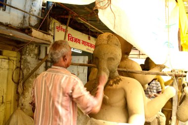 Nagpur, Maharashtra - 3 Ağustos 2014: Sanatçı 3 Ağustos 2014 'te Hindistan' ın Maharashtra kentinde Ganesha-Festivali için bir sanatçı atölyesinde Hindu tanrısı Lord Ganesha 'nın bir putuna son rötuşlarını yaptı..