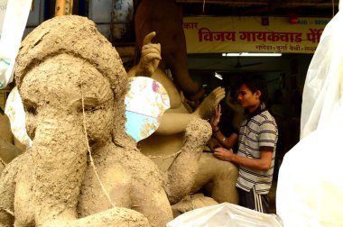 Nagpur, Maharashtra - 3 Ağustos 2014: Sanatçı 3 Ağustos 2014 'te Hindistan' ın Maharashtra kentinde Ganesha-Festivali için bir sanatçı atölyesinde Hindu tanrısı Lord Ganesha 'nın bir putuna son rötuşlarını yaptı..