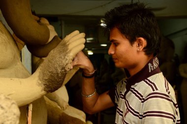 Nagpur, Maharashtra - 3 Ağustos 2014: Sanatçı 3 Ağustos 2014 'te Hindistan' ın Maharashtra kentinde Ganesha-Festivali için bir sanatçı atölyesinde Hindu tanrısı Lord Ganesha 'nın bir putuna son rötuşlarını yaptı..