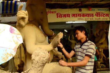 Nagpur, Maharashtra - 3 Ağustos 2014: Sanatçı 3 Ağustos 2014 'te Hindistan' ın Maharashtra kentinde Ganesha-Festivali için bir sanatçı atölyesinde Hindu tanrısı Lord Ganesha 'nın bir putuna son rötuşlarını yaptı..
