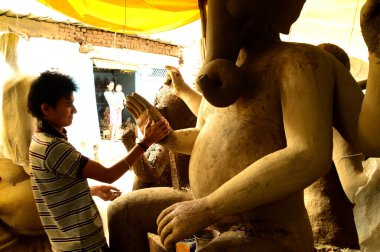 Nagpur, Maharashtra - 3 Ağustos 2014: Sanatçı 3 Ağustos 2014 'te Hindistan' ın Maharashtra kentinde Ganesha-Festivali için bir sanatçı atölyesinde Hindu tanrısı Lord Ganesha 'nın bir putuna son rötuşlarını yaptı..