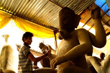 Nagpur, Maharashtra - 3 Ağustos 2014: Sanatçı 3 Ağustos 2014 'te Hindistan' ın Maharashtra kentinde Ganesha-Festivali için bir sanatçı atölyesinde Hindu tanrısı Lord Ganesha 'nın bir putuna son rötuşlarını yaptı..