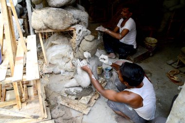 Nagpur, Maharashtra - 3 Ağustos 2014: Sanatçı 3 Ağustos 2014 'te Hindistan' ın Maharashtra kentinde Ganesha-Festivali için bir sanatçı atölyesinde Hindu tanrısı Lord Ganesha 'nın bir putuna son rötuşlarını yaptı..