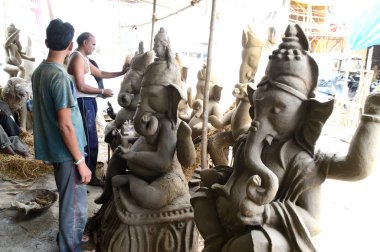 Nagpur, Maharashtra - 3 Ağustos 2014: Sanatçı 3 Ağustos 2014 'te Hindistan' ın Maharashtra kentinde Ganesha-Festivali için bir sanatçı atölyesinde Hindu tanrısı Lord Ganesha 'nın bir putuna son rötuşlarını yaptı..