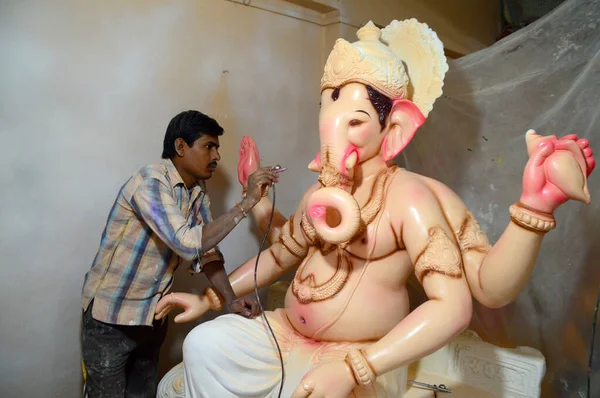 MUMBAI, MAHARASHTRA - 24 AUGUST 2014 : Artist gives finishing touches on an idol of the Hindu god Lord Ganesha at an artist's workshop for Ganesha-festival, 24 August 2014, Maharashtra, India. — Stock Photo, Image