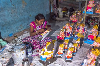 AMRAVATI, MAHARASHTRA - SEPTEMBER 4, 2016: Artist making a statue and gives finishing touches on an idol of the Hindu god Lord Ganesha at an artist's workshop for Ganesha festival.