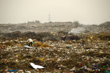 Amravati, Maharashtra, Hindistan - 09 Nisan 2014: Çöpte tanımlanamayan bez toplayıcıları geri dönüşümlü malzeme arıyorlar. Hindistan 'daki kara ve hava kirliliği 09 Nisan 2014' te, Amravati, Hindistan.