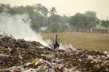 Amravati, Maharashtra, Hindistan - 09 Nisan 2014: Çöpte tanımlanamayan bez toplayıcıları geri dönüşümlü malzeme arıyorlar. Hindistan 'daki kara ve hava kirliliği 09 Nisan 2014' te, Amravati, Hindistan.