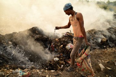 Amravati, Maharashtra, Hindistan - 09 Nisan 2014: Çöpte tanımlanamayan bez toplayıcıları geri dönüşümlü malzeme arıyorlar. Hindistan 'daki kara ve hava kirliliği 09 Nisan 2014' te, Amravati, Hindistan.