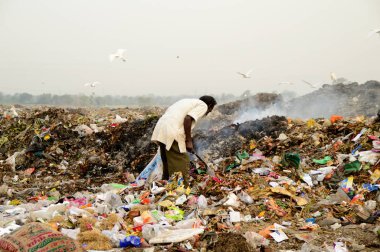 Amravati, Maharashtra, Hindistan - 09 Nisan 2014: Çöpte tanımlanamayan bez toplayıcıları geri dönüşümlü malzeme arıyorlar. Hindistan 'daki kara ve hava kirliliği 09 Nisan 2014' te, Amravati, Hindistan.