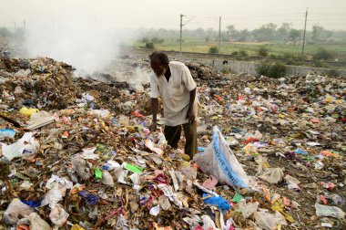 Amravati, Maharashtra, Hindistan - 09 Nisan 2014: Çöpte tanımlanamayan bez toplayıcıları geri dönüşümlü malzeme arıyorlar. Hindistan 'daki kara ve hava kirliliği 09 Nisan 2014' te, Amravati, Hindistan.