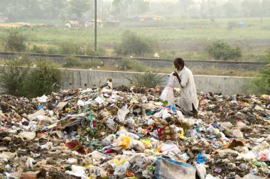 Amravati, Maharashtra, Hindistan - 09 Nisan 2014: Çöpte tanımlanamayan bez toplayıcıları geri dönüşümlü malzeme arıyorlar. Hindistan 'daki kara ve hava kirliliği 09 Nisan 2014' te, Amravati, Hindistan.