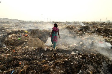Amravati, Maharashtra, Hindistan - 09 Nisan 2014: Çöpte tanımlanamayan bez toplayıcıları geri dönüşümlü malzeme arıyorlar. Hindistan 'daki kara ve hava kirliliği 09 Nisan 2014' te, Amravati, Hindistan.