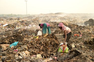 Amravati, Maharashtra, Hindistan - 09 Nisan 2014: Çöpte tanımlanamayan bez toplayıcıları geri dönüşümlü malzeme arıyorlar. Hindistan 'daki kara ve hava kirliliği 09 Nisan 2014' te, Amravati, Hindistan.