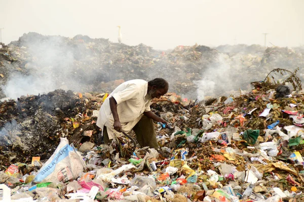 Amravati, Maharashtra, Hindistan - 09 Nisan 2014: Çöpte tanımlanamayan bez toplayıcıları geri dönüşümlü malzeme arıyorlar. Hindistan 'daki kara ve hava kirliliği 09 Nisan 2014' te, Amravati, Hindistan.