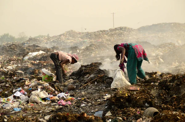 Amravati, Maharashtra, Hindistan - 09 Nisan 2014: Çöpte tanımlanamayan bez toplayıcıları geri dönüşümlü malzeme arıyorlar. Hindistan 'daki kara ve hava kirliliği 09 Nisan 2014' te, Amravati, Hindistan.