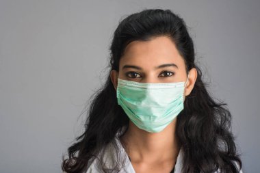 Tıbbi ya da cerrahi maske takan genç bir kız ya da kadın doktorun yakın plan portresi