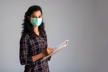 Kan testi için Coronavirus konsepti. Coronavirus testi için tıbbi test formu okuyan ya da dolduran genç bir kız.