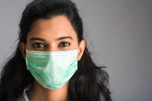 Tıbbi ya da cerrahi maske takan genç bir kız ya da kadın doktorun yakın plan portresi