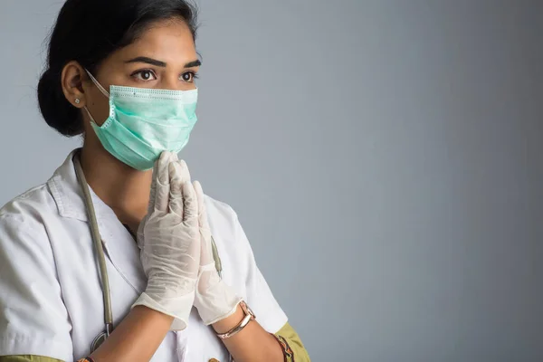 Young woman Doctor doing Namaste because of outbreak of COVID-19. New greeting to avoid the spread of coronavirus instead of greeting with a hug or handshake.