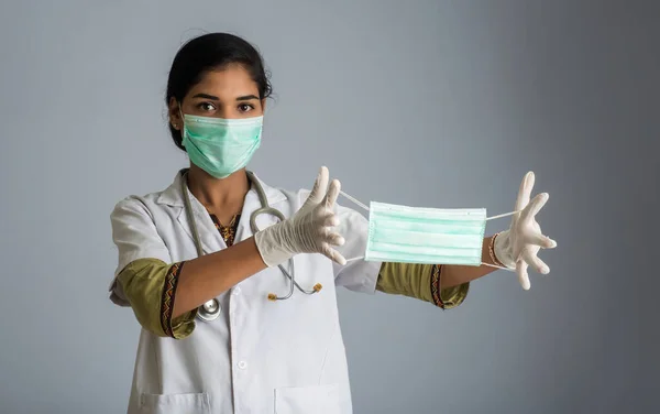 Portrait of young woman doctor showing opened medical mask. quarantine measures and life saving concept