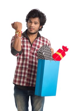 Raksha Bandhan festivali vesilesiyle ellerinde alışveriş poşetleri ve hediye kutusuyla rakhi gösteren genç adamlar..