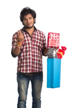Raksha Bandhan festivali vesilesiyle ellerinde alışveriş poşetleri ve hediye kutusuyla rakhi gösteren genç adamlar..