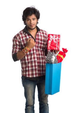 Raksha Bandhan festivali vesilesiyle ellerinde alışveriş poşetleri ve hediye kutusuyla rakhi gösteren genç adamlar..