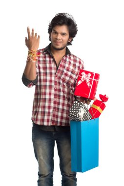 Raksha Bandhan festivali vesilesiyle ellerinde alışveriş poşetleri ve hediye kutusuyla rakhi gösteren genç adamlar..
