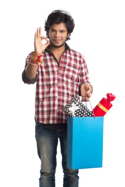 Raksha Bandhan festivali vesilesiyle ellerinde alışveriş poşetleri ve hediye kutusuyla rakhi gösteren genç adamlar..